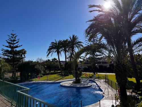 una piscina con palmeras en un parque en Estudio Marbella, en Marbella