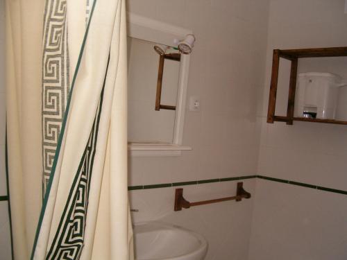Un baño con cortina de ducha y lavabo. en Residencial Augusta, en Islantilla