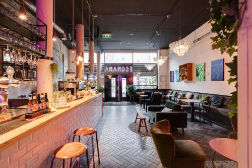 un restaurante con un bar con mesas y sillas en Ecomama en Ámsterdam