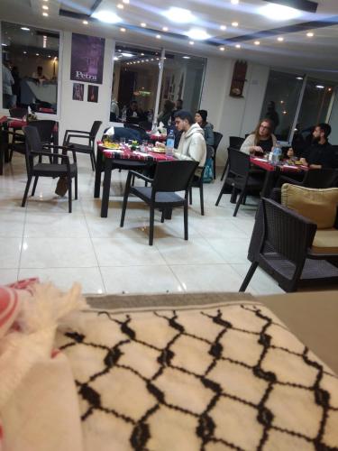 a group of people sitting at tables in a restaurant at Rose city inn in Wadi Musa