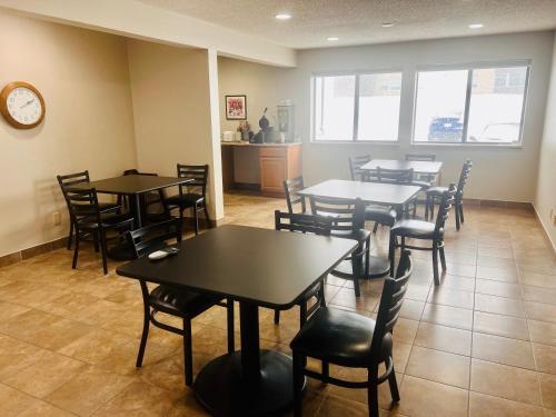 a dining room with tables and chairs and a clock at Super 8 by Wyndham Humboldt in Humboldt