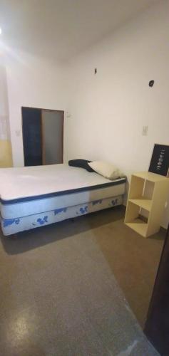 1 dormitorio con 1 cama y 1 silla en Alquiler temporal Villa Regina en Villa Regina