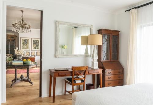 a bedroom with a desk and a table with a mirror at Byron Studio Apartment in Suffolk Park