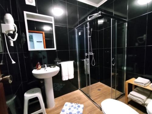 a bathroom with a sink and a shower at Apartamentos Lisboa in Vila do Porto