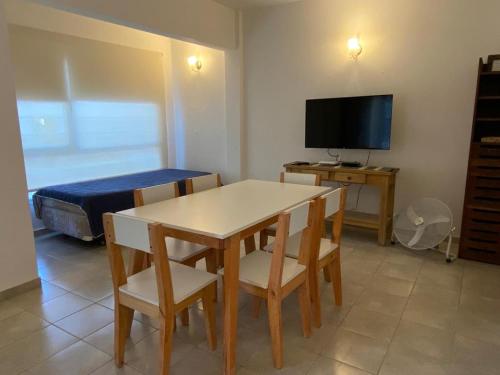 a room with a table and a bed and a television at Muy lindo departamento! in Puerto Madryn