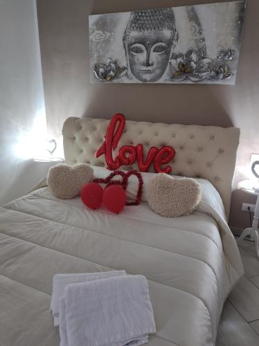 a white bed with two stuffed animals on it at Mary Gery's Rooms in Castellammare del Golfo
