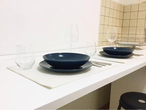 two black bowls and wine glasses sitting on a counter at Appartamento Teatro Massimo in Catania