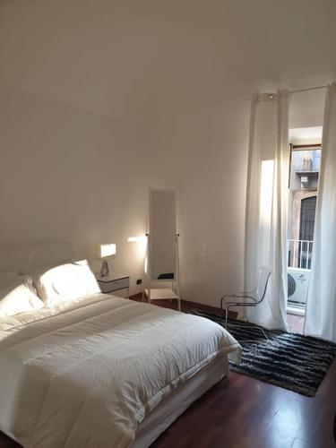 a bedroom with a white bed and a window at Appartamento Teatro Massimo in Catania