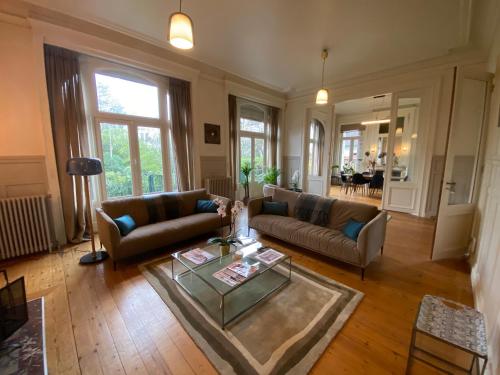 un salon avec deux canapés et une table en verre dans l'établissement Maison Colodge DELORY BARBIEUX, à Roubaix