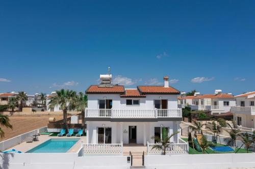 a large white house with a swimming pool at Villa suncity Boutique Beachfront in Ayia Napa