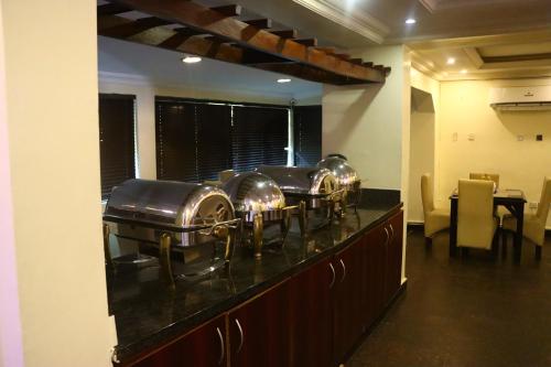 a row of copper kettles on a kitchen counter at Presken K-ONE in Ikeja