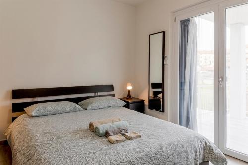 1 dormitorio con 1 cama con 2 toallas en Il Gattino di Porto - apt 2 - Bilocale terrazzo piscina, en Imperia
