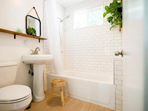 a bathroom with a white tub and a toilet and a sink at The Zen - Outdoor Shower, Gas Fireplace, Walkable to Shops & Restaurants in Joshua Tree