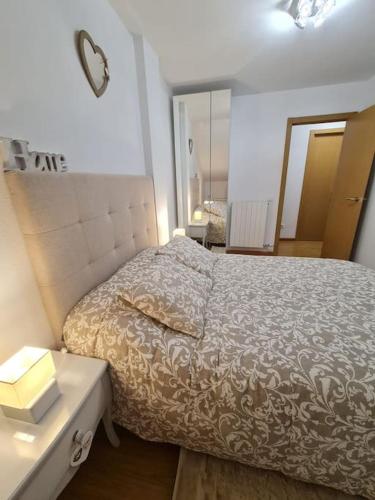 a bedroom with a bed and a dresser and a mirror at Nuevo apartamento de dos plantas in Renedo de Piélagos