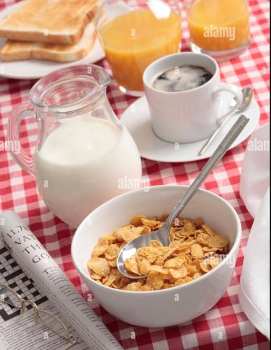 a bowl of cereal and a cup of milk on a table at MACs Belfast in Belfast