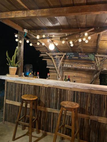 a wooden bar with two stools in front of it at BONITA HOSTEL in Palomino