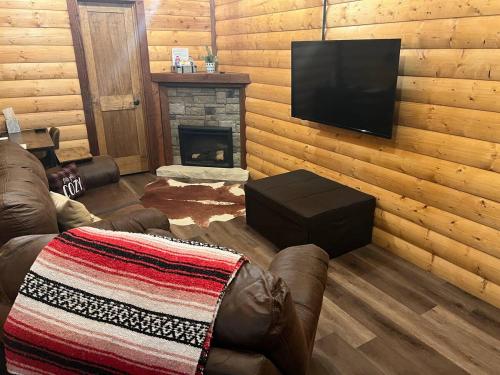 a living room with a couch and a television at Limestone Lodge in Sabetha