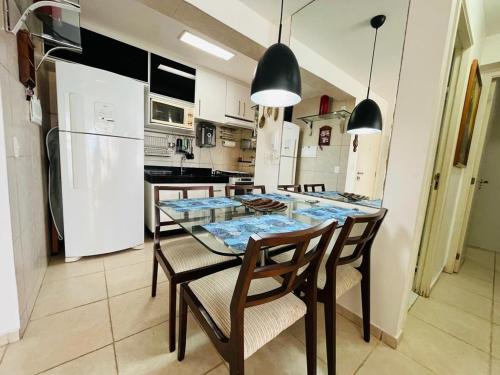 cocina con mesa, sillas y nevera en Cond. Beach Village Residence 1, en Fortaleza