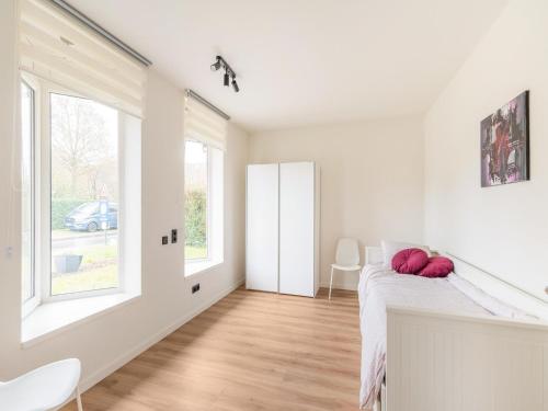 Habitación blanca con 1 cama y 2 ventanas en Modern holiday home in Houthalen-Helchteren with garden, 