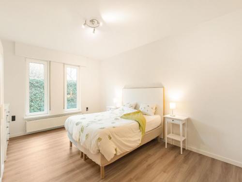 1 dormitorio blanco con 1 cama y 2 ventanas en Modern holiday home in Houthalen-Helchteren with garden, 
