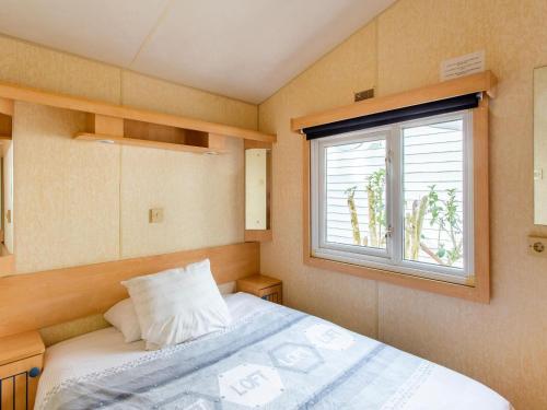 a small bedroom with a bed and a window at Mobile Home in Var near Miramar Beach in La Londe-les-Maures