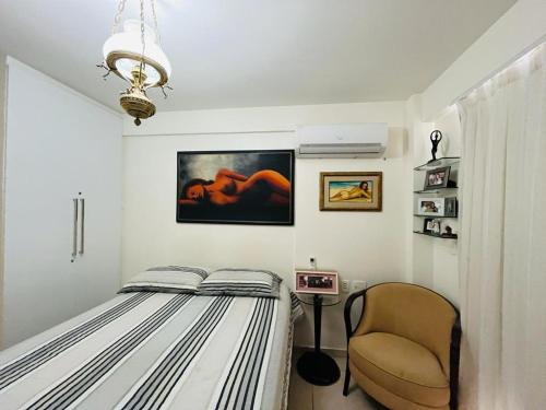 1 dormitorio con 1 cama y 1 silla en Cond. Beach Village Residence 1, en Fortaleza