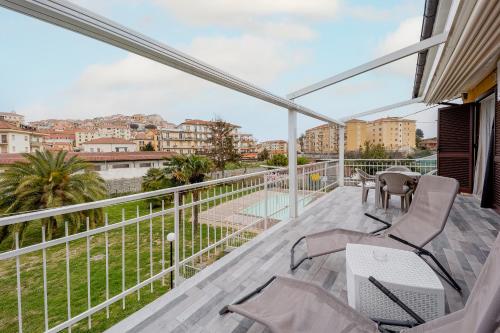 a balcony with chairs and a view of the city at Il Gattino di Porto - apt 5 - Bilocale terrazzo piscina in Imperia