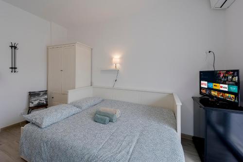 a small bedroom with a bed with a tv on it at Il Gattino di Porto - apt 6 - Monolocale terrazzo piscina in Imperia