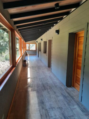 an empty hallway of a house with wood floors and windows at Le Bouquet Apart Hotel in San Carlos de Bariloche