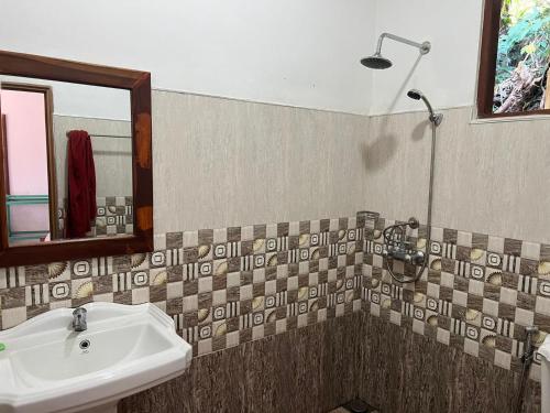 La salle de bains est pourvue d'un lavabo et d'une douche. dans l'établissement Saddle Cottage, à Ella