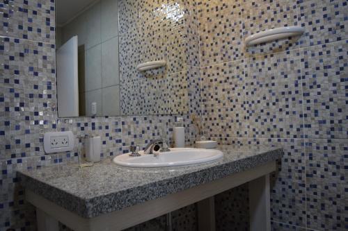 y baño con lavabo y espejo. en La Recalada Departamentos en Concepción del Uruguay