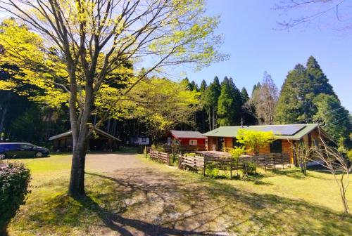 a cabin in the woods with a tree at 藤のヴィラ チェリー棟 Self Check-in in Aso