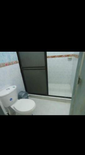 a bathroom with a white toilet and a mirror at Casa el remanso in Acacías