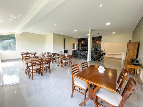 a dining room with wooden tables and chairs at Pousadinha Campos in Campos do Jordão