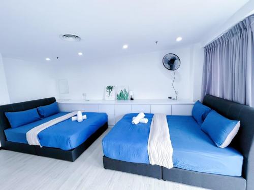 Duas camas num quarto com almofadas azuis em Sunrise Gurney #CityView #GurneyDrive #FamilyStay em George Town