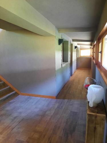 an empty hallway with stairs and a room with wood floors at Le Bouquet Apart Hotel in San Carlos de Bariloche