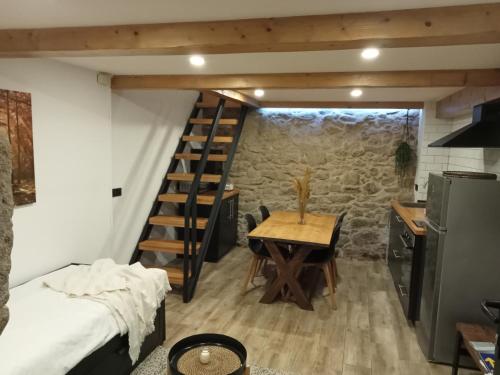 a room with a staircase and a table and a kitchen at A Casiña da Ponte in Padrón