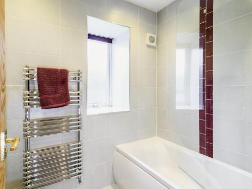 uma casa de banho com uma banheira, um WC e uma janela. em The Byre em Kirkcudbright
