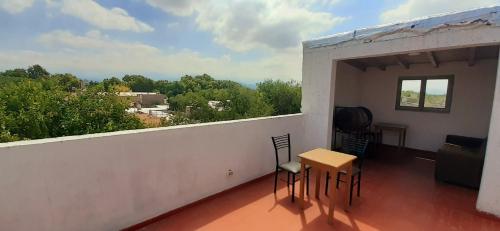 Habitación con balcón con mesa y sillas. en Departamento Pascual Toso en Villa Nueva
