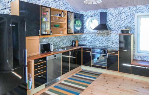uma cozinha com utensílios de aço inoxidável e armários de madeira em Amazing Home In Kalmar With House Sea View em Kalmar