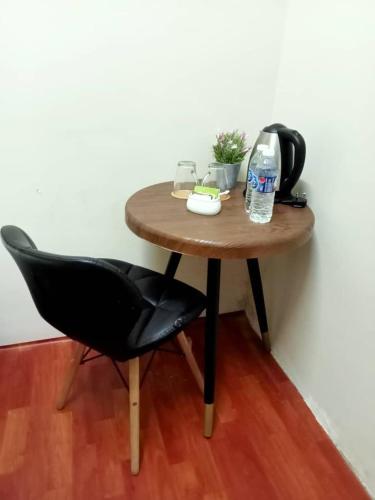 a table with a chair and a coffee maker on it at Aeropod Hostel Economy Twin Room in Kapayan