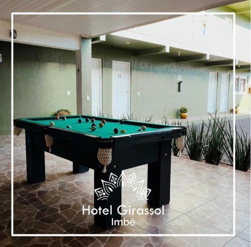 a pool table sitting on a patio with a pool at Hotel Girassol in Imbé