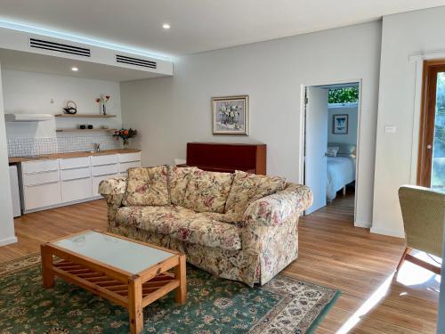 a living room with a couch and a table at Tranquil Garden Apartment with living room in Wollongong