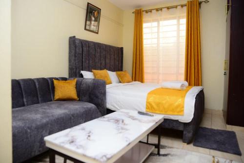 a living room with a bed and a couch at Elegant studio apartment in Kitengela 