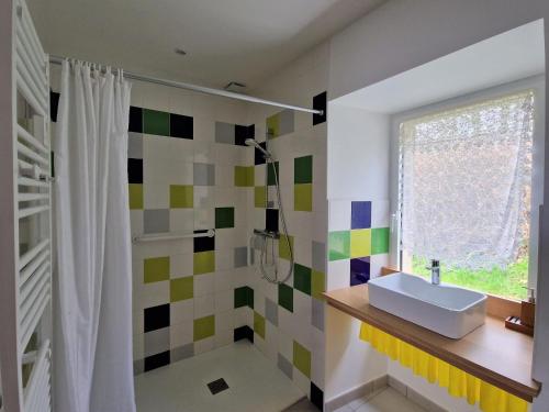 La salle de bains est pourvue d'un lavabo et d'une douche. dans l'établissement Finistère house 15 minutes from the bay of Morlaix, 
