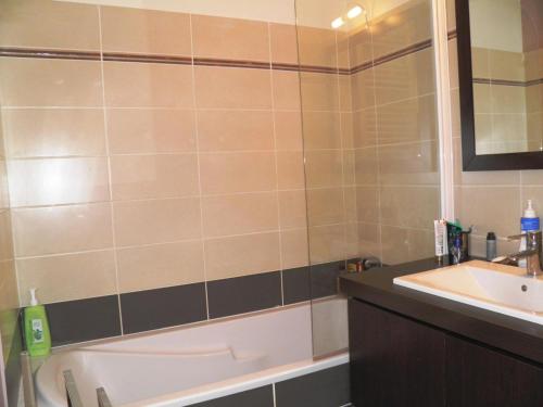 une salle de bain avec une baignoire et un lavabo dans l'établissement Belle villa moderne avec piscine, 800m plage, parking privé et clim, idéale pour familles à Sète - FR-1-338-31, à Sète