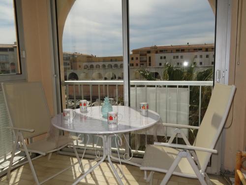 une table blanche et des chaises sur un balcon dans l'établissement Appartement lumineux 2P avec loggia et parking à Sète - FR-1-338-70, à Sète