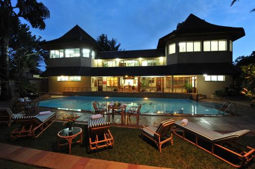 a house with a swimming pool in front of it at Mimosa Court Apartments in Nairobi