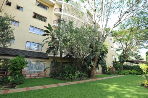 an apartment building with a tree in the yard at Mimosa Court Apartments in Nairobi
