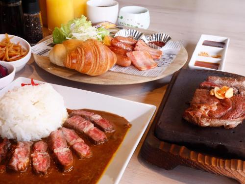 two plates of food on a table with rice and meat at Hotel Abest Osu Kannon Ekimae Hane no Yu in Nagoya